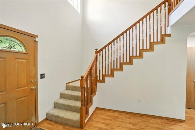 22030 Birch Creek Dr, Chugiak, AK 99567 - foyer entrance featuring stairs, light wood-style floors, a towering ceiling, and baseboards