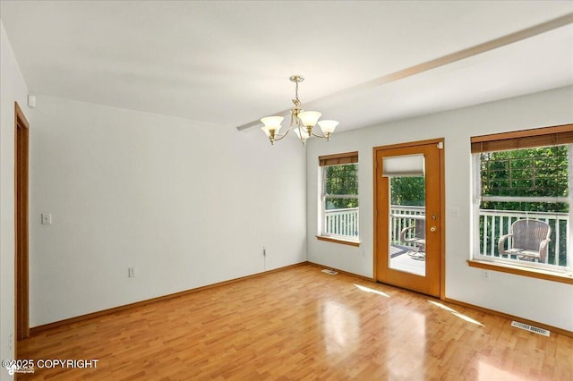 22030 Birch Creek Dr, Chugiak, AK 99567 - empty room with healthy amount of natural light, a chandelier, light wood-type flooring, and baseboards