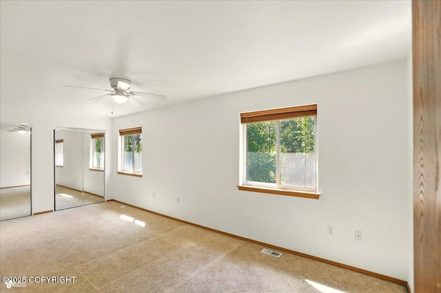 22030 Birch Creek Dr, Chugiak, AK 99567 - unfurnished bedroom featuring multiple windows, carpet floors, and multiple closets