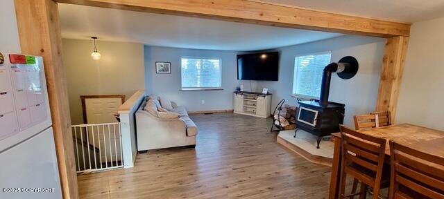301 Teal Way, Kodiak, AK 99615 - living room featuring wood finished floors, a wood stove, healthy amount of natural light, and baseboards