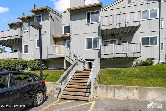 4109 Lynn Dr # 121, Anchorage, AK 99508 - view of building exterior with stairs and uncovered parking