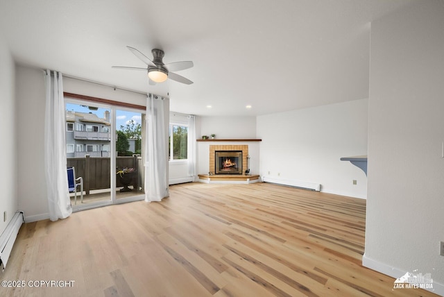 4109 Lynn Dr # 121, Anchorage, AK 99508 - unfurnished living room with ceiling fan, wood finished floors, a fireplace, a baseboard radiator, and recessed lighting