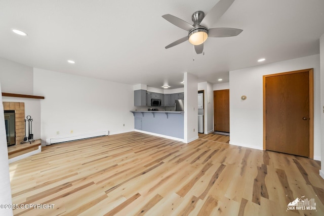 4109 Lynn Dr # 121, Anchorage, AK 99508 - unfurnished living room with a baseboard heating unit, ceiling fan, recessed lighting, light wood finished floors, and a glass covered fireplace