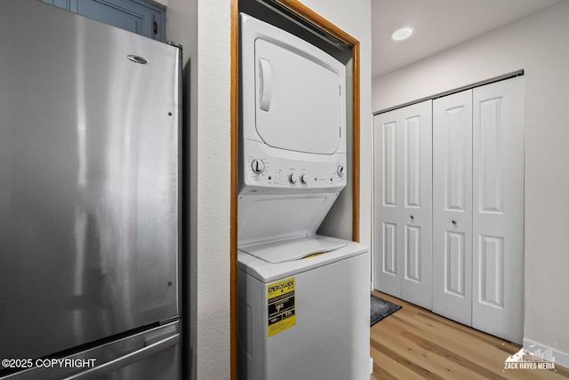 4109 Lynn Dr # 121, Anchorage, AK 99508 - washroom featuring estacked washer and dryer and light wood-type flooring