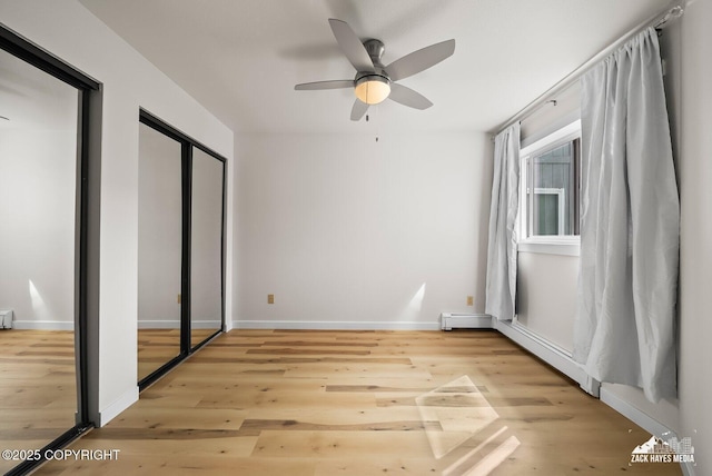 4109 Lynn Dr # 121, Anchorage, AK 99508 - unfurnished bedroom featuring wood finished floors, a baseboard heating unit, and a ceiling fan