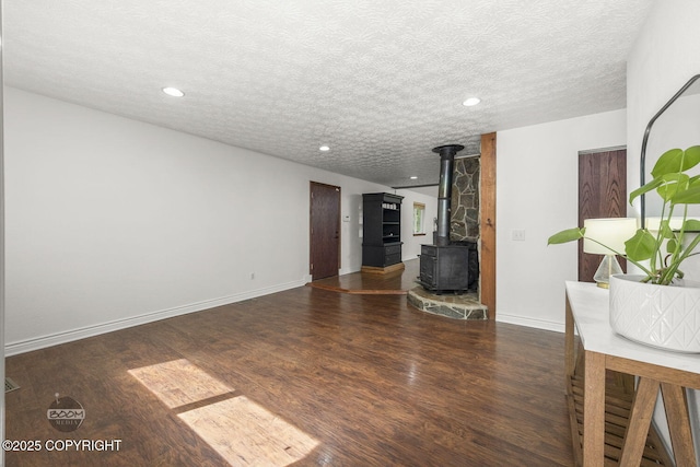 9845 E Lee Ann Dr, Palmer, AK 99645 - unfurnished living room with a wood stove, wood finished floors, a textured ceiling, recessed lighting, and baseboards