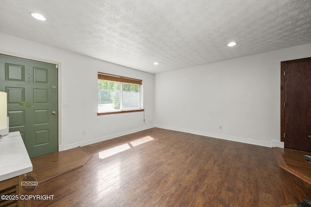 9845 E Lee Ann Dr, Palmer, AK 99645 - unfurnished living room with dark wood finished floors, a textured ceiling, baseboards, and recessed lighting
