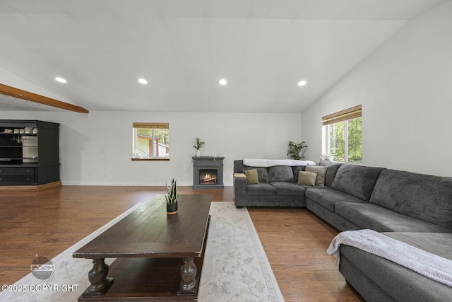 9845 E Lee Ann Dr, Palmer, AK 99645 - living area featuring vaulted ceiling, wood finished floors, recessed lighting, a warm lit fireplace, and baseboards