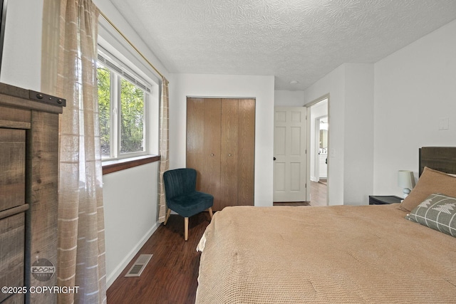 9845 E Lee Ann Dr, Palmer, AK 99645 - bedroom with wood finished floors, baseboards, a closet, and a textured ceiling