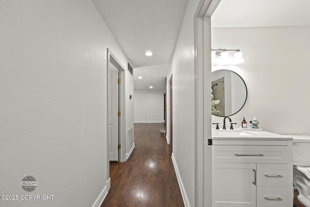 9845 E Lee Ann Dr, Palmer, AK 99645 - hall featuring a sink, dark wood-style flooring, baseboards, recessed lighting, and a textured wall