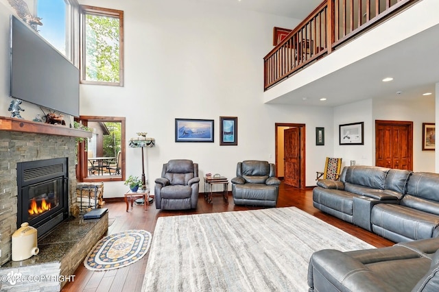 34952 Treeline Ave, Soldotna, AK 99669 - living area featuring a towering ceiling, a stone fireplace, wood finished floors, and recessed lighting