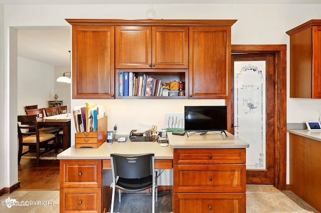 34952 Treeline Ave, Soldotna, AK 99669 - kitchen featuring built in study area, light countertops, a kitchen breakfast bar, and brown cabinets