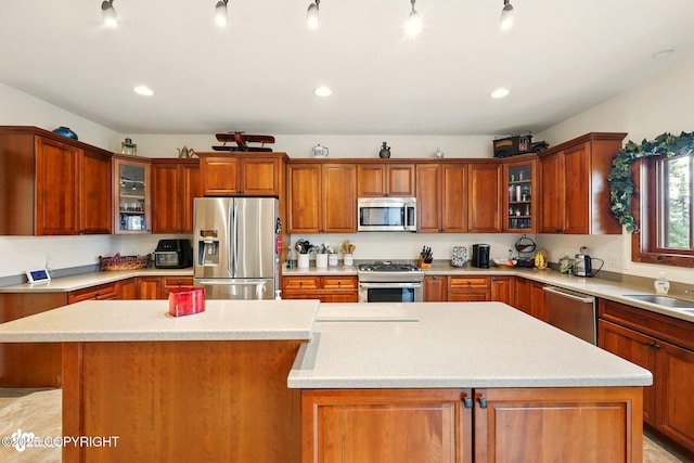 34952 Treeline Ave, Soldotna, AK 99669 - kitchen featuring appliances with stainless steel finishes, light countertops, a kitchen island, brown cabinets, and recessed lighting