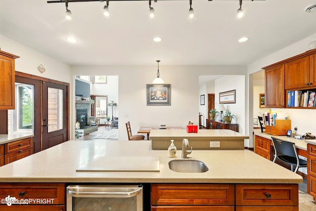 34952 Treeline Ave, Soldotna, AK 99669 - kitchen featuring a kitchen island with sink, light countertops, brown cabinetry, dishwashing machine, and recessed lighting