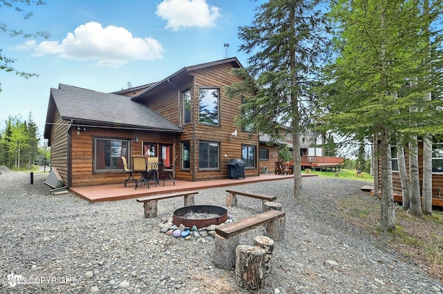 34952 Treeline Ave, Soldotna, AK 99669 - back of house with a fire pit, a deck, and roof with shingles