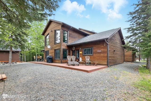 34952 Treeline Ave, Soldotna, AK 99669 - rear view of house with a wooden deck, driveway, and roof with shingles
