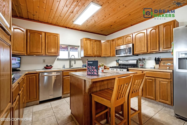 3745 W Machen Rd, Wasilla, AK 99623 - kitchen with stainless steel appliances, light tile patterned floors, a kitchen island, brown cabinets, and wooden ceiling
