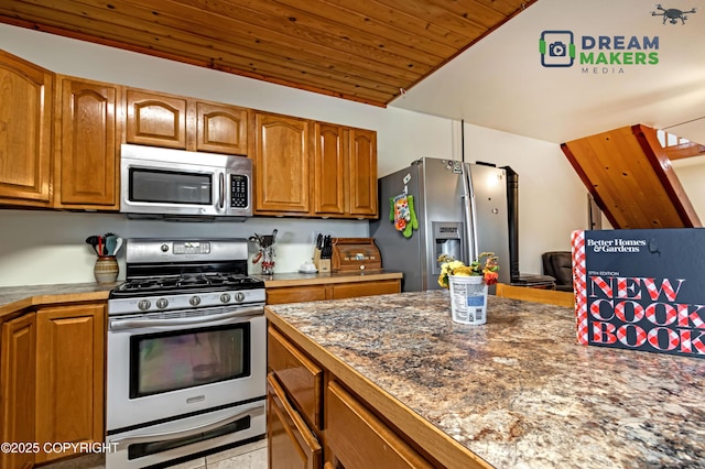 3745 W Machen Rd, Wasilla, AK 99623 - kitchen featuring stainless steel appliances, brown cabinetry, wood ceiling, and vaulted ceiling
