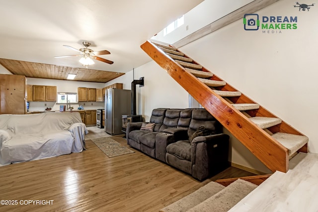3745 W Machen Rd, Wasilla, AK 99623 - living area with light wood-type flooring, stairs, a wood stove, and ceiling fan