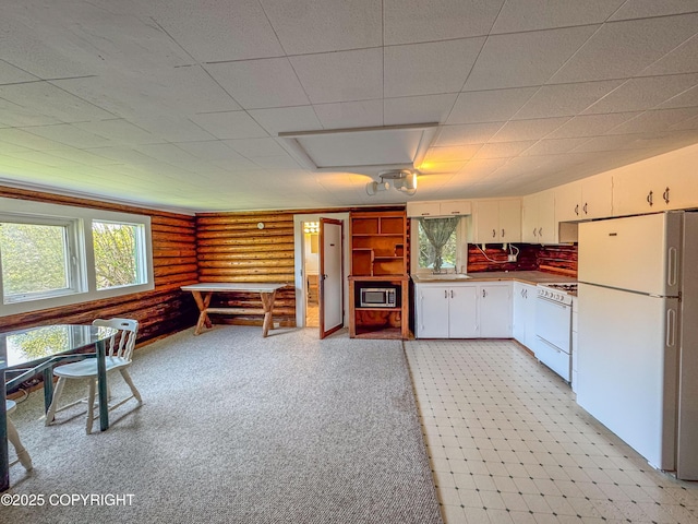 4075 Mattox Rd, Homer, AK 99603 - kitchen featuring white appliances, a sink, rustic walls, and white cabinetry