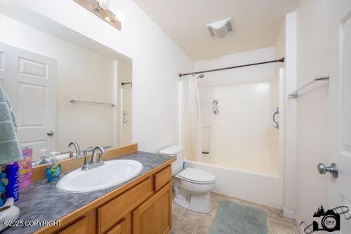 500 W Roy Rd, Wasilla, AK 99654 - bathroom with vanity, toilet, shower / bathtub combination with curtain, and tile patterned floors
