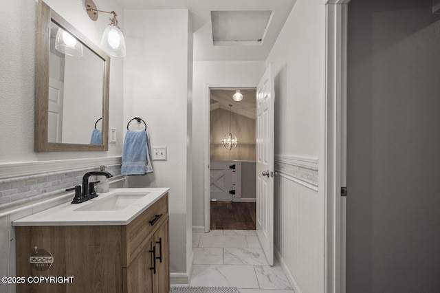 19113 Sarichef Loop, Eagle River, AK 99577 - bathroom featuring marble look tile flooring, vanity, and a wainscoted wall