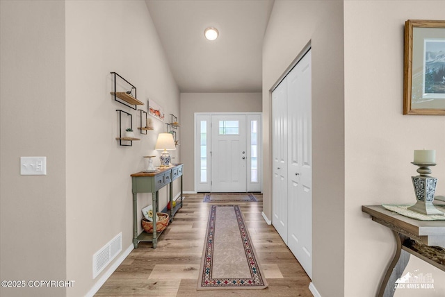 8620 Jade St, Anchorage, AK 99502 - foyer with light wood-style flooring, baseboards, and lofted ceiling