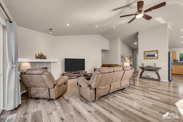 8620 Jade St, Anchorage, AK 99502 - living area with light wood-style flooring, vaulted ceiling, ceiling fan, recessed lighting, and a high end fireplace