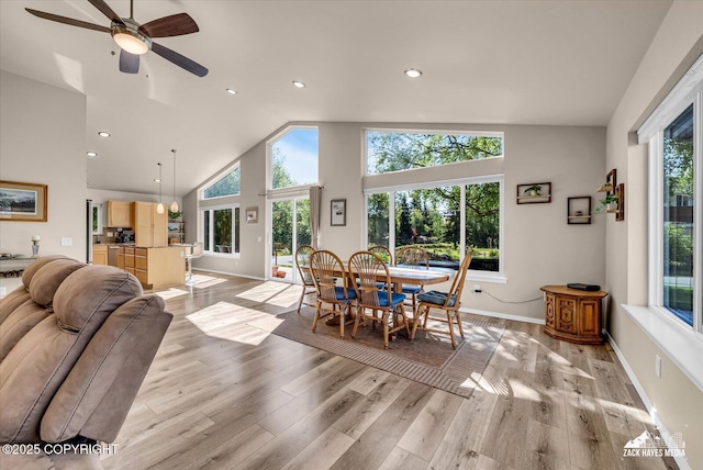 8620 Jade St, Anchorage, AK 99502 - dining area featuring plenty of natural light, light wood finished floors, baseboards, recessed lighting, and high vaulted ceiling