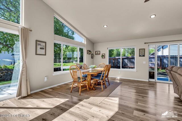 8620 Jade St, Anchorage, AK 99502 - dining area with baseboards, healthy amount of natural light, wood finished floors, recessed lighting, and high vaulted ceiling