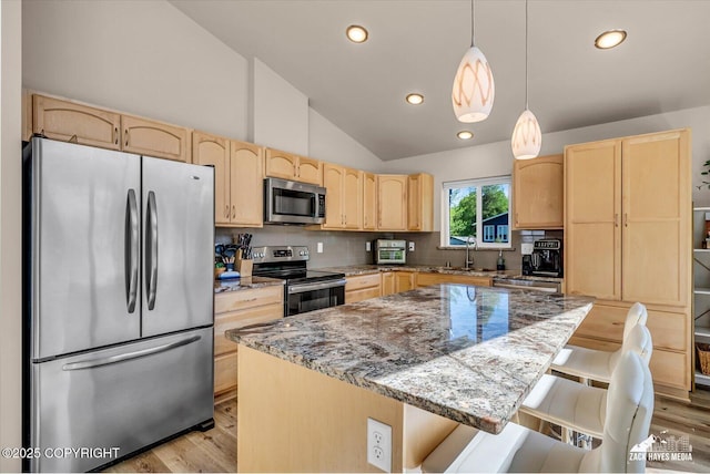 8620 Jade St, Anchorage, AK 99502 - kitchen with appliances with stainless steel finishes, light brown cabinets, a sink, light wood-style flooring, and vaulted ceiling