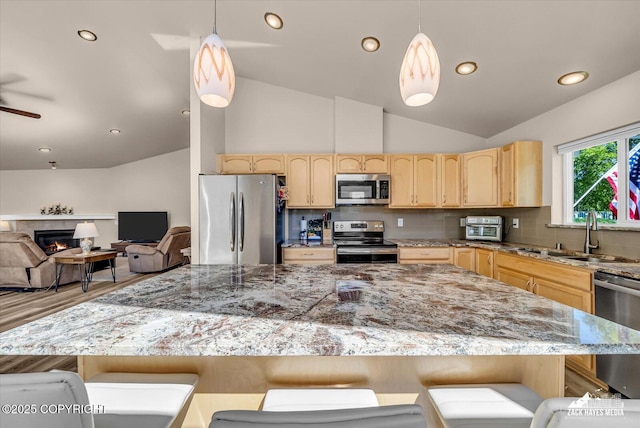 8620 Jade St, Anchorage, AK 99502 - kitchen featuring stainless steel appliances, light brown cabinetry, decorative backsplash, vaulted ceiling, and a sink