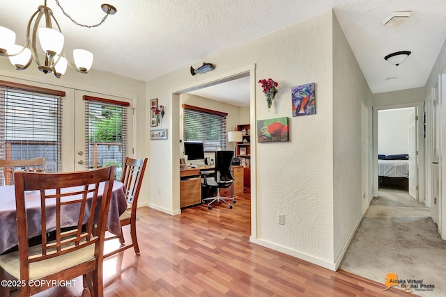 4139 Cosmos Dr, Anchorage, AK 99517 - dining space featuring an office area, light wood-style flooring, a chandelier, french doors, and a textured wall