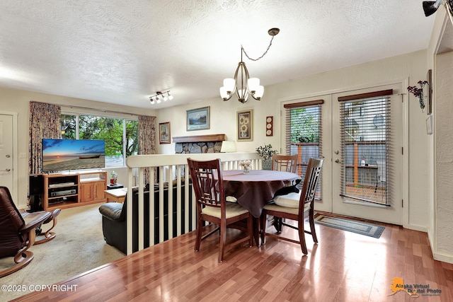 4139 Cosmos Dr, Anchorage, AK 99517 - dining space featuring a textured ceiling, wood finished floors, and a chandelier