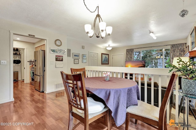 4139 Cosmos Dr, Anchorage, AK 99517 - dining area featuring a chandelier and light wood-style flooring
