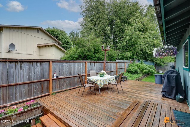 4139 Cosmos Dr, Anchorage, AK 99517 - wooden terrace featuring a fenced backyard, outdoor dining area, and a grill