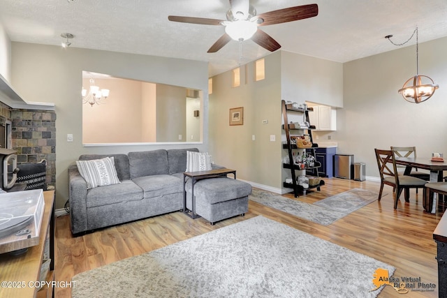 218 Deerfield Dr, Anchorage, AK 99515 - living room featuring a chandelier, a ceiling fan, light wood finished floors, and vaulted ceiling