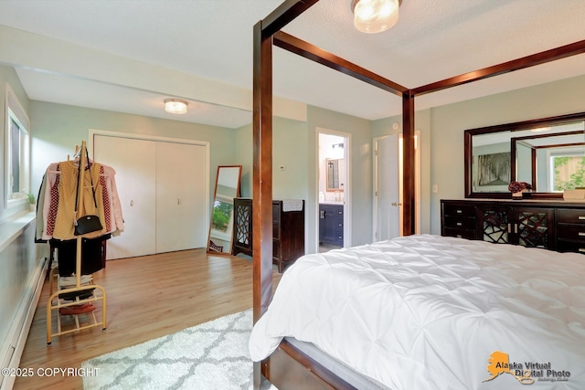 218 Deerfield Dr, Anchorage, AK 99515 - bedroom featuring wood finished floors, a baseboard radiator, and ensuite bathroom