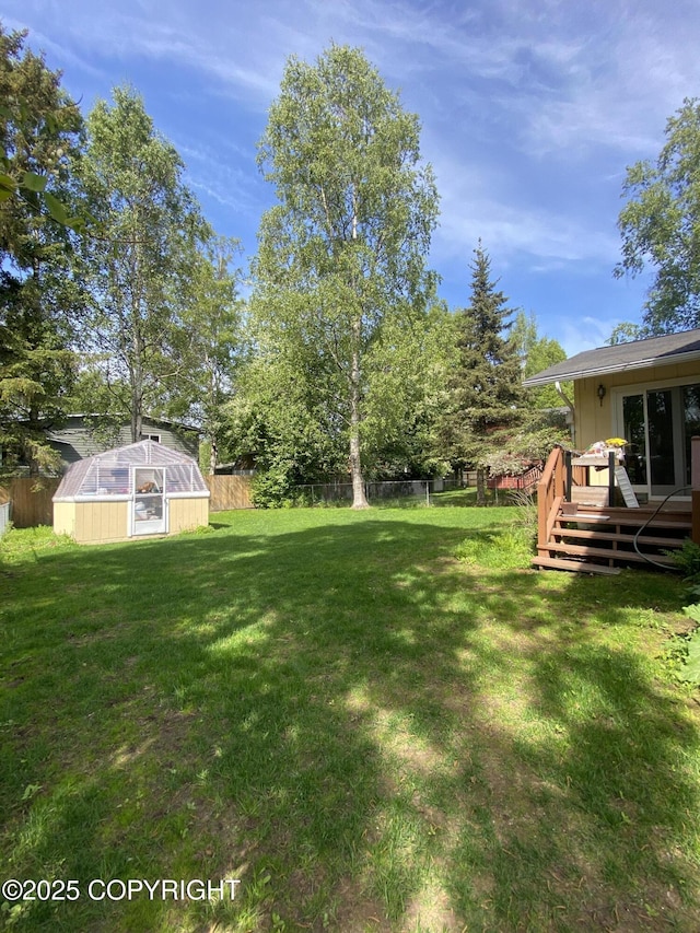 3316 Vassar Dr, Anchorage, AK 99508 - view of yard featuring an exterior structure, a deck, and an outbuilding