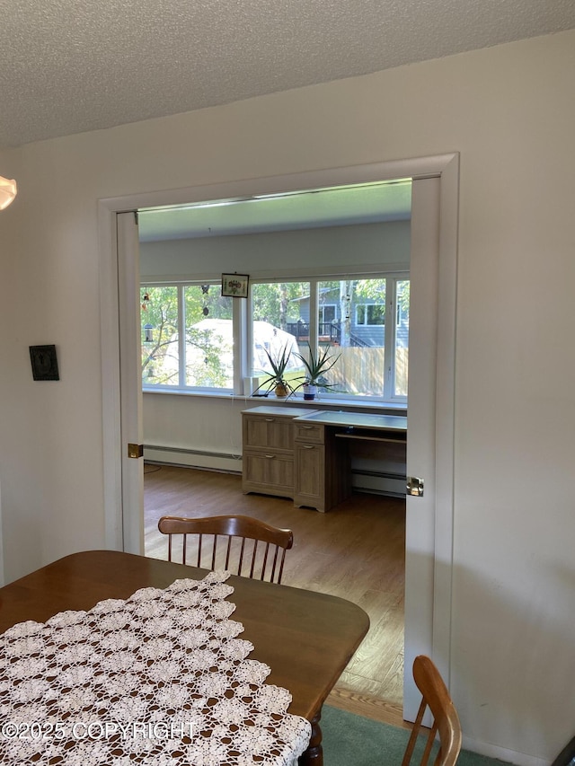 3316 Vassar Dr, Anchorage, AK 99508 - dining space with a baseboard heating unit, light wood-style floors, a textured ceiling, and a desk