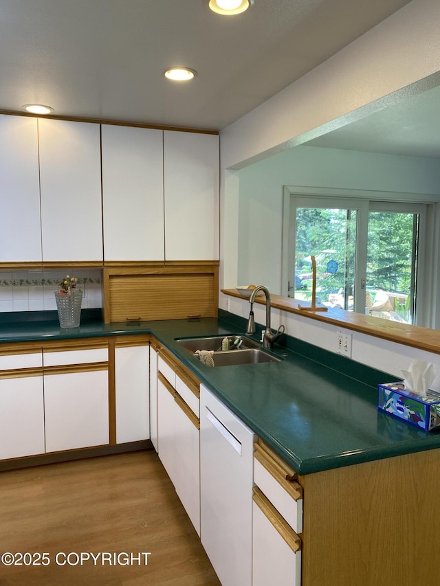 3316 Vassar Dr, Anchorage, AK 99508 - kitchen featuring white dishwasher, a sink, white cabinets, dark countertops, and light wood-style floors