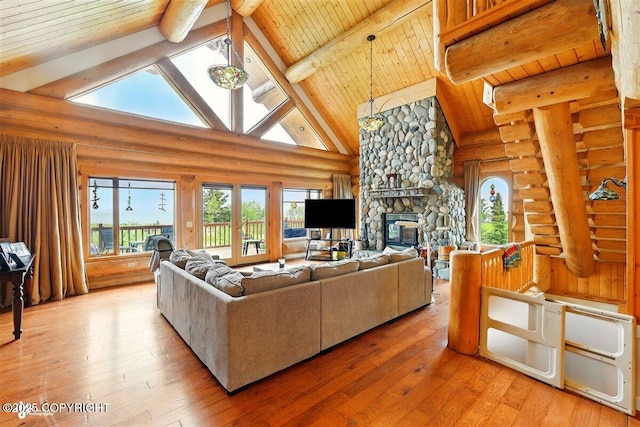 22325 Sterling Hwy, Ninilchik, AK 99639 - living room featuring log walls, plenty of natural light, hardwood / wood-style floors, a stone fireplace, and wooden ceiling with exposed beams