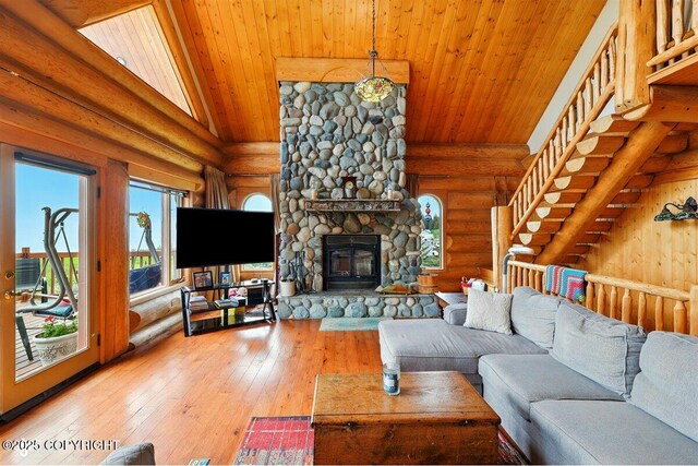 22325 Sterling Hwy, Ninilchik, AK 99639 - living area with rustic walls, wood ceiling, light wood-type flooring, a stone fireplace, and high vaulted ceiling