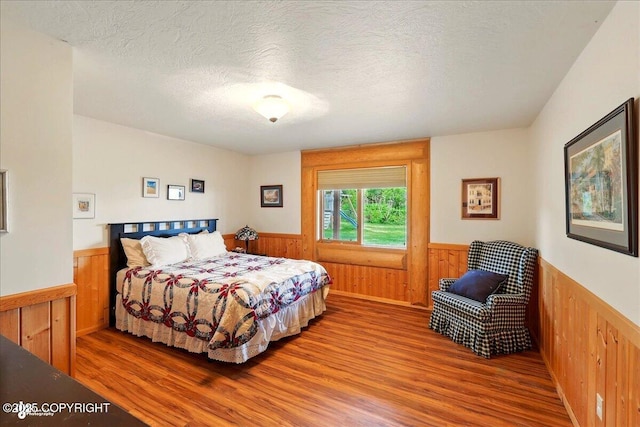 22325 Sterling Hwy, Ninilchik, AK 99639 - bedroom featuring a wainscoted wall, wooden walls, and wood finished floors