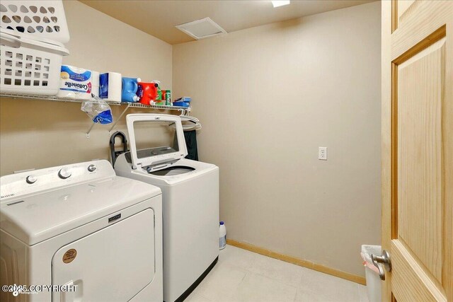 22325 Sterling Hwy, Ninilchik, AK 99639 - laundry area with washing machine and dryer, baseboards, and light tile patterned flooring