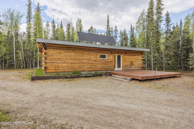 2390 Hermits Way N, Pole, AK 99705 - back of house with log exterior, a wooden deck, and a view of trees