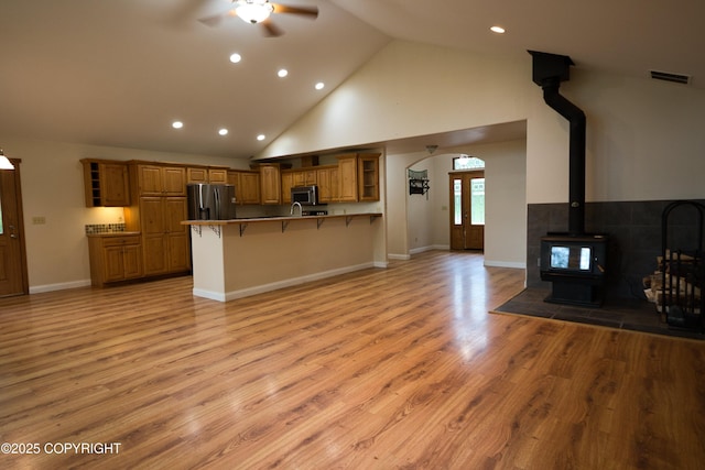 11838 N Hagion Shores Dr, Willow, AK 99688 - kitchen with appliances with stainless steel finishes, open shelves, a breakfast bar, open floor plan, and brown cabinets