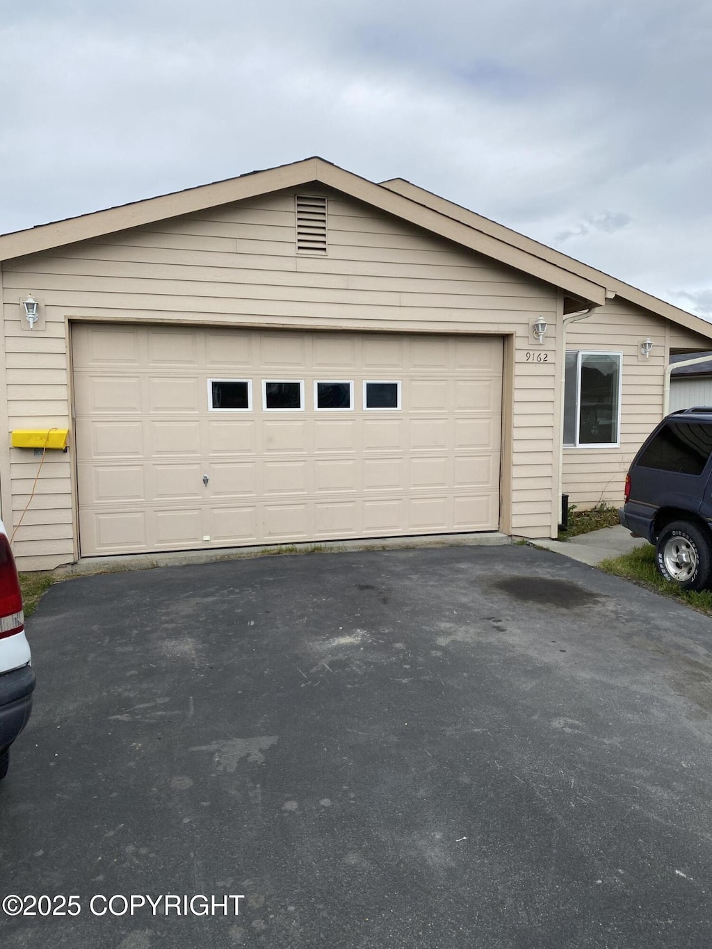 9162 Aphrodite Dr, Anchorage, AK 99515 - view of home's exterior featuring a garage and asphalt driveway