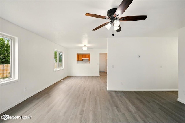 557 N Glenn Hwy, Palmer, AK 99645 - unfurnished living room featuring plenty of natural light, wood finished floors, a ceiling fan, and baseboards