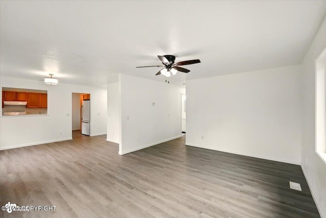 557 N Glenn Hwy, Palmer, AK 99645 - unfurnished living room with wood finished floors, ceiling fan, and baseboards